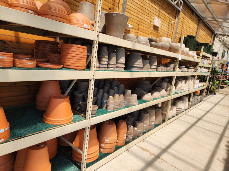 Shelves filled with colorful flowerpots of various shapes and sizes.