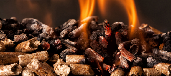 A close-up of wood pellets burning in a pellet stove.