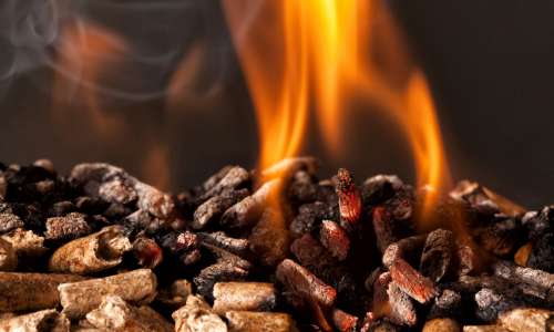 A close-up of wood pellets burning in a pellet stove.